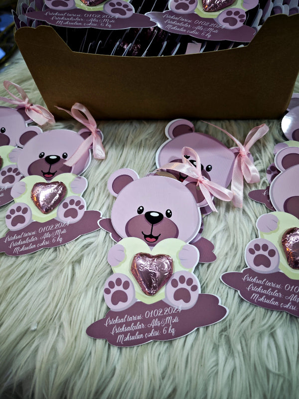 Purple bear-shaped cards with pink bows on a textured surface
