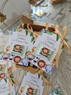 Gift boxes with lion-themed birthday party decorations on a textured surface.