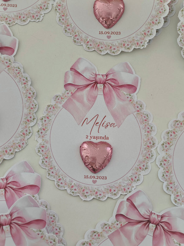 Decorative card with pink heart and bow design, featuring text and a floral border.