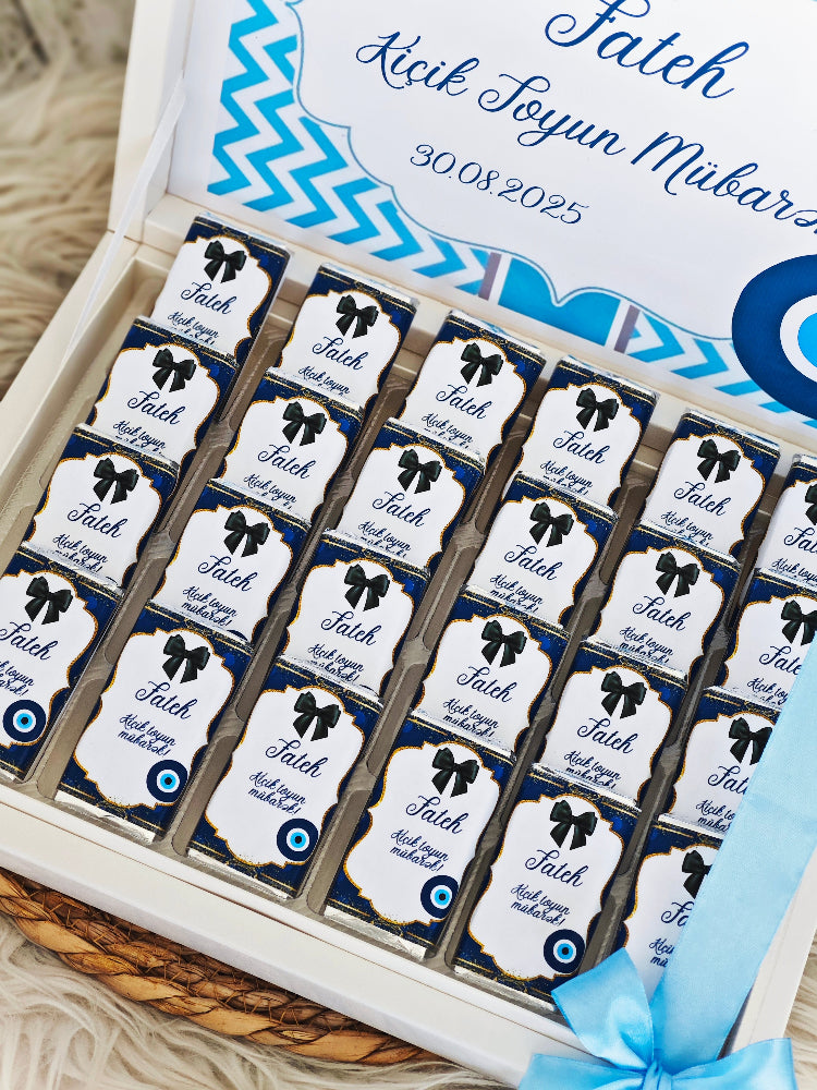 Box of chocolates with personalized labels on a wooden surface