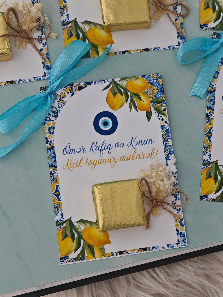 Decorative card with gold box, lemons, and blue ribbon on a matching background
