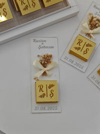Personalized wedding favor with initials 'R' and 'S', date '31.08.2025', and dried flowers on a white background.