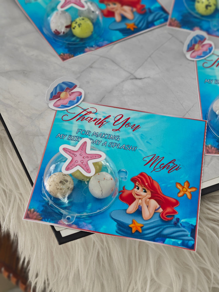 Children's party favor with 'The Little Mermaid' theme, featuring a card and decorative elements.