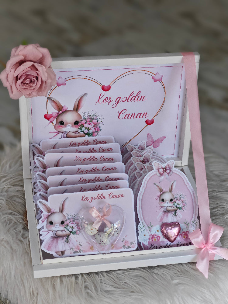 Set of cards with cute bunny design and pink ribbon on a textured surface