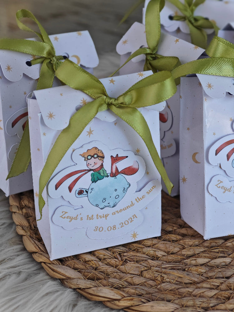 Gift boxes with green ribbons and cartoon character on a woven surface