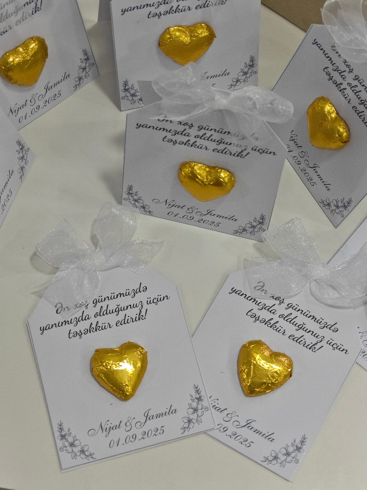 Gold heart-shaped earrings on white cards with text, displayed on a white surface.
