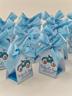 Small triangular boxes with blue bows and car illustrations on a light background