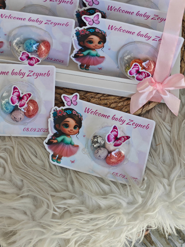 Stickers with a baby girl design and 'Welcome baby Zeyneb' text on a textured surface.