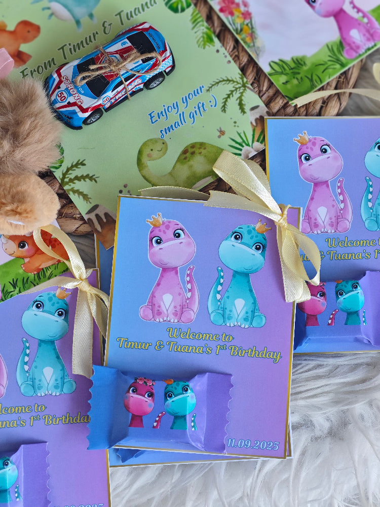 Children's birthday party favor boxes with dinosaur design and personalized text.