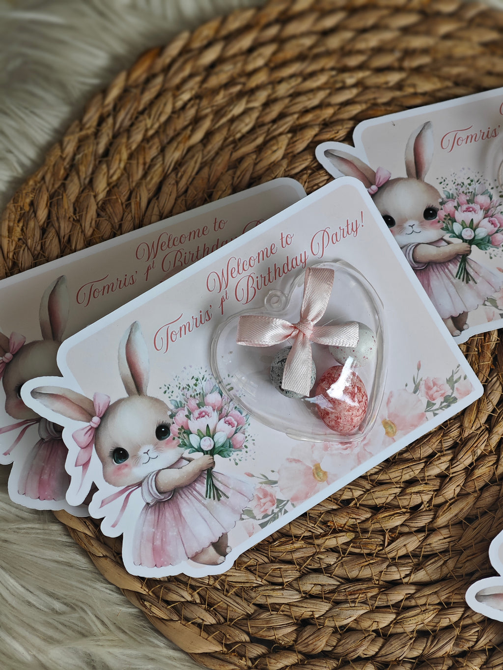 Decorative rabbit-themed party invitations on a woven mat
