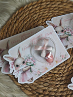 Decorative rabbit-themed party invitations on a woven mat