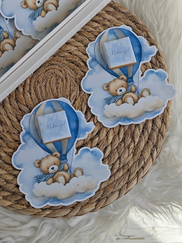Decorative wreath with teddy bear and hot air balloon design on a textured surface.