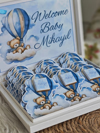 Set of personalized baby shower favors with teddy bears and hot air balloons, featuring 'Welcome Baby Mikayl'.