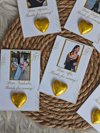 Gold heart-shaped earrings on personalized cards on a woven surface