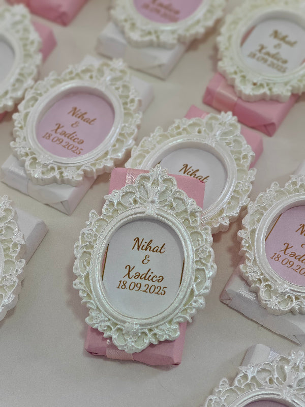Decorative wedding invitations with lace frames and pink ribbons.