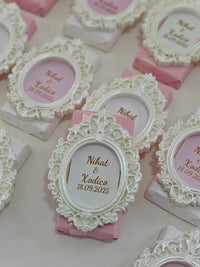 Decorative wedding invitations with lace frames and pink ribbons.