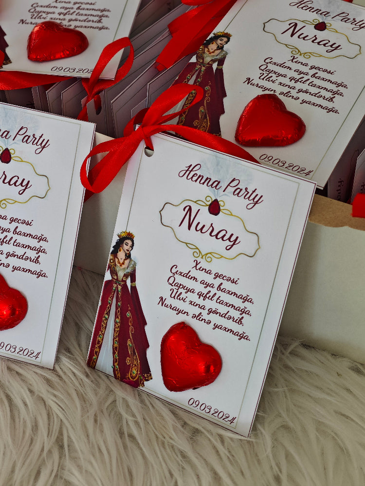 Henna Party invitations with red ribbons and heart designs on a textured surface.
