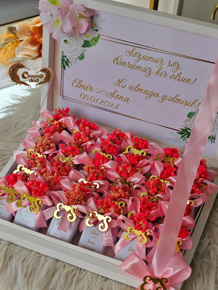 Decorative box with red flowers and pink ribbons, featuring a personalized message.
