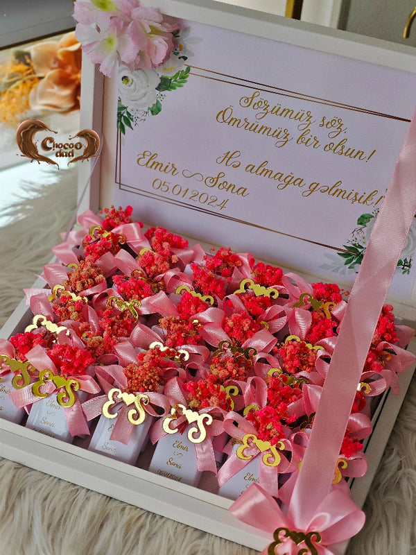 Decorative box with red flowers and pink ribbons, featuring a personalized message.