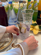 Person holding a card with a product on a table with drinks and snacks