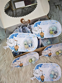 Set of baby-themed earrings in packaging on a wooden surface