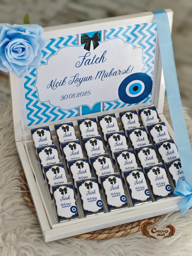 Box of chocolates with blue and white design, featuring a rose on top.