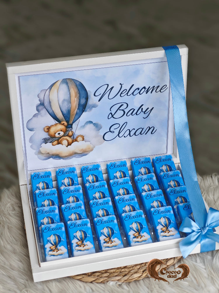 Gift box with blue chocolates and teddy bear design, featuring 'Welcome Baby Elxan'.